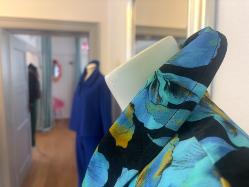 Bunte Bluse mit floralem Muster, im Vordergrund, im Modestore.